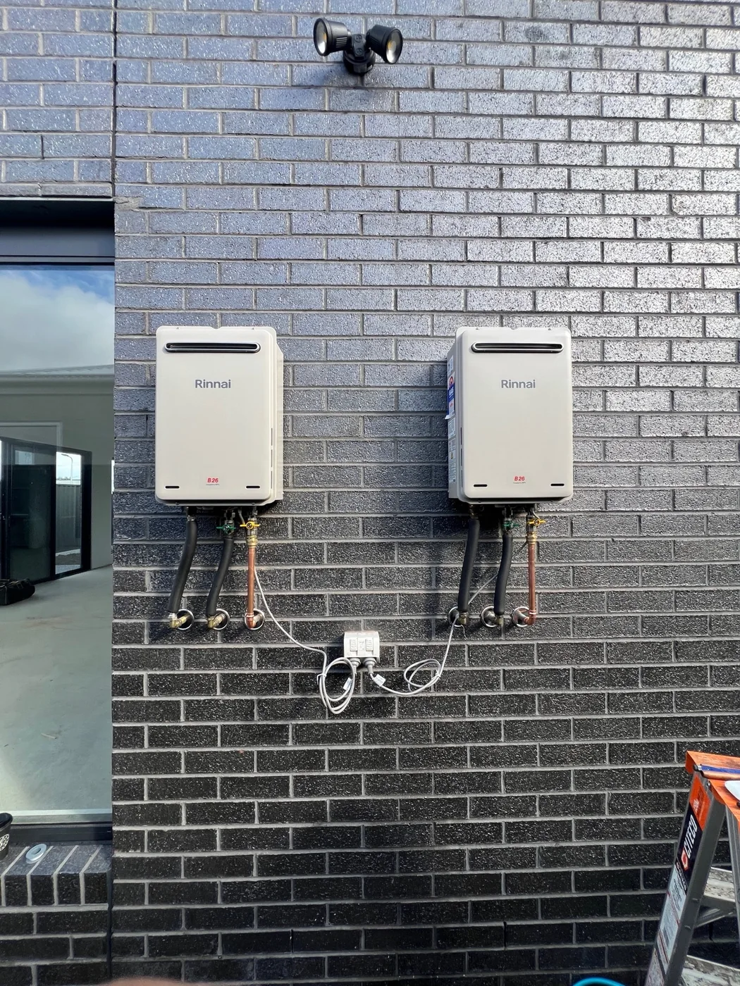 Two wall-mounted hot water units with connected pipework